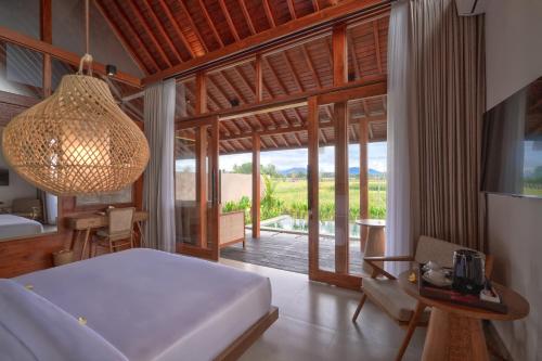 a bedroom with a bed and a room with a view at Pondok Raka Ubud in Ubud