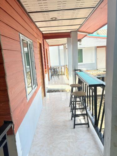 una casa con un patio con mesa y taburetes en เกาะลิบงKohlibong forest house, en Trang