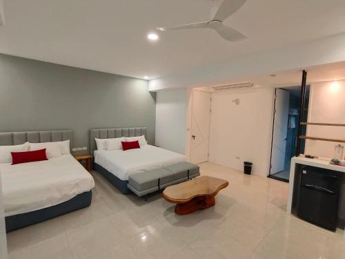 a hotel room with two beds and a ceiling fan at Blissful Moments in Donghe