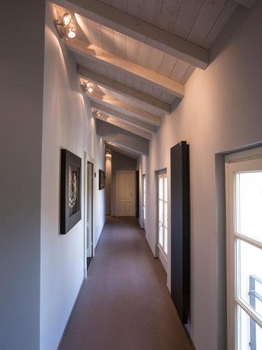 a hallway in a house with white walls and a window at Palazzo Gozzi Bed & Beauty in Parma