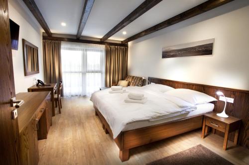 a bedroom with a large bed with white sheets at Hotel Kraví Hora in Bořetice