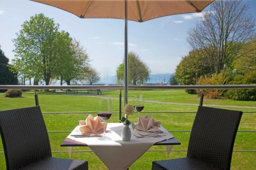 a table with two chairs and an umbrella on a patio at Hotel Lipprandt in Wasserburg