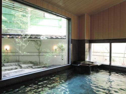 a pool of water in a room with a large window at Senso Yutagawa in Tsuruoka