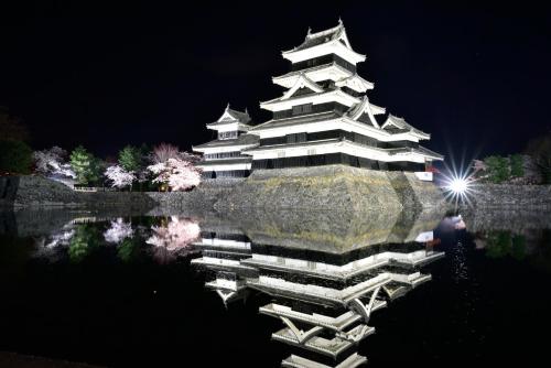 a building with a reflection in the water at night at Yumotoya in Matsumoto
