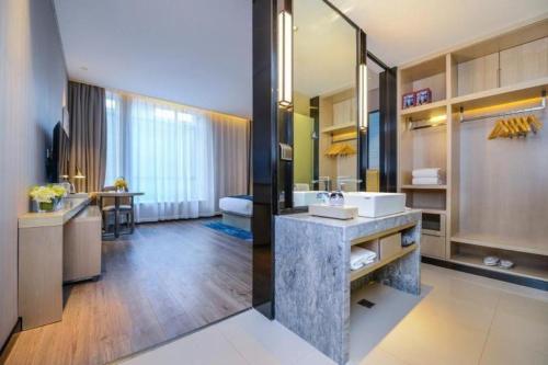 Un baño con lavabo y un espejo grande. en Echarm Hotel Anshun High-speed Railway Station Jichang Road, en Anshun