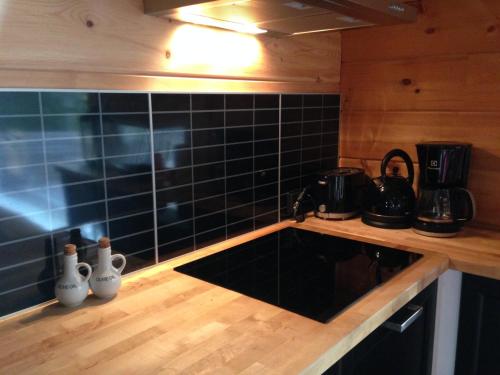 a kitchen with black tiled walls and a counter top at Villa Kuukkeli in Salla