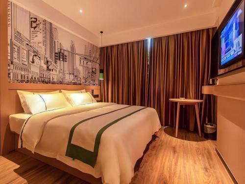una camera d'albergo con un letto e una televisione di City Comfort Inn Changsha Huanghua Airport Yong'an a Yong'an