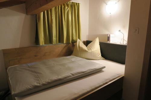 a bed in a room with a green window at Apartment Madlaina in Samnaun