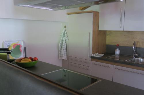 a kitchen with a sink and a bowl of fruit on a counter at Apartment Madlaina in Samnaun
