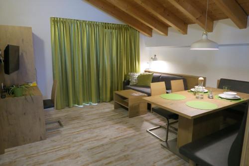 a living room with a table and a green curtain at Apartment Madlaina in Samnaun
