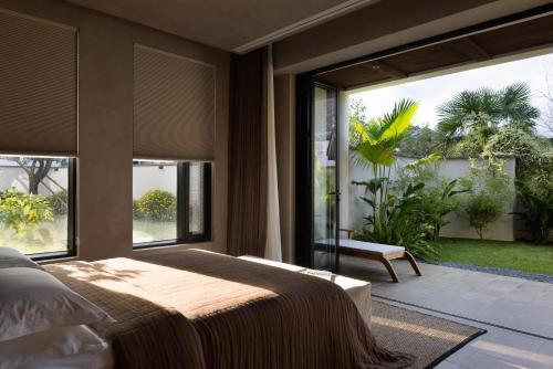 a bedroom with a bed and a large window at ANALO Resort Hotel in Lijiang