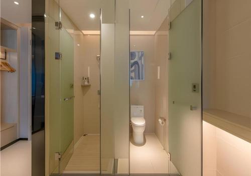 un bagno con wc e doccia in vetro di Echarm Hotel Nanning Wuxiang Headquarters Base a Nanning