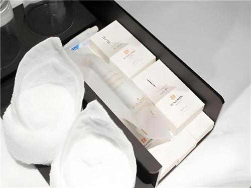 uma caixa preta cheia de envelopes brancos e meias brancas em Borrman Hotel Changsha Wuyi Square Yingbin Road Metro Station em Changsha