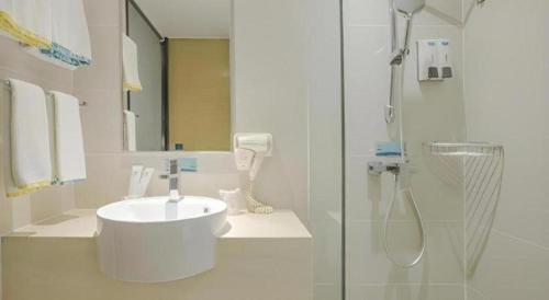 a white bathroom with a sink and a shower at City Comfort Inn Nanning Wuyi Road Department of Motor Vehicles in Nanning