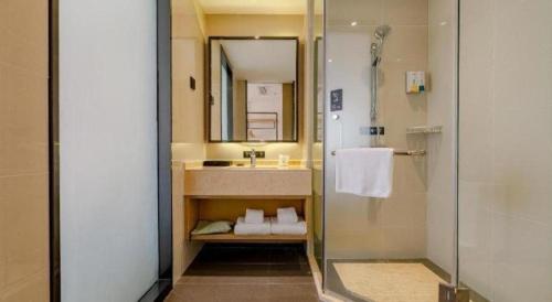 ein Badezimmer mit Waschbecken, Spiegel und Dusche in der Unterkunft City Comfort Inn Chengdu Wenjiang Zhujiang Square Guanghua Park Metro Station in Chengdu