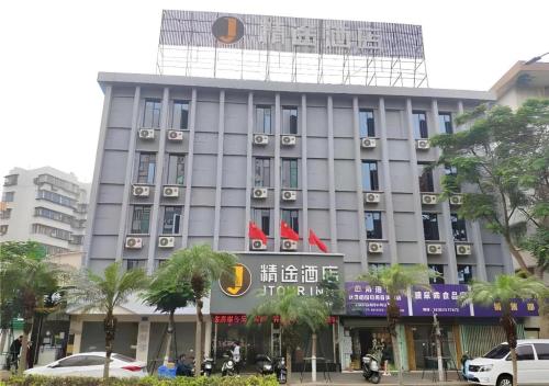 湛江JTOUR Inn Zhanjiang Poly Yuandian Plaza的一座前面有标志的高楼
