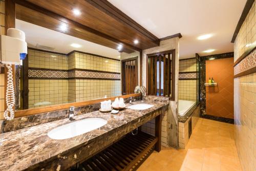 a bathroom with two sinks and a large mirror at Nak Nakara Hotel in Chiang Rai