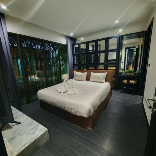 a bedroom with a bed with a towel on it at Chalong Modern 2 bedroom pool villa 2 minutes to fitness street and many tourist attractions in Ban Suan