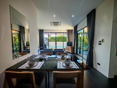 a dining room with a table and chairs at Chalong Modern 2 bedroom pool villa 2 minutes to fitness street and many tourist attractions in Ban Suan