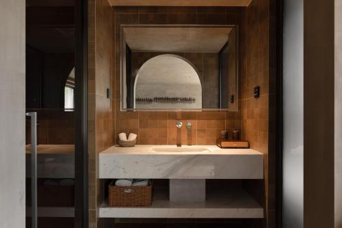 a bathroom with a sink and a mirror at ANALO Resort Hotel in Lijiang
