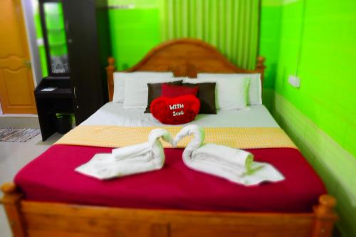 a bedroom with a bed with two towels on it at Stream Garden Mountain Resort in Kalpetta