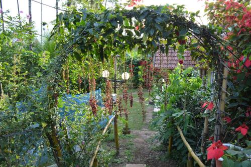 an archway in a garden with flowers and plants at Stream Garden Mountain Resort in Kalpetta