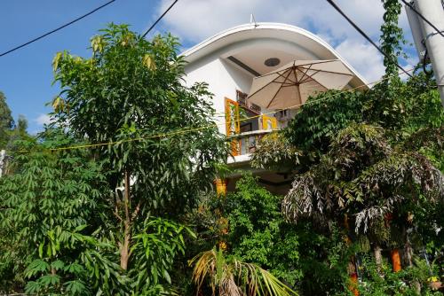 a building with a balcony with an umbrella at NGO KHANH Homestay in Tân Hiệp