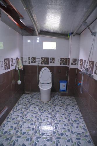 a bathroom with a toilet and a tiled floor at San's House in Hữu Lũng