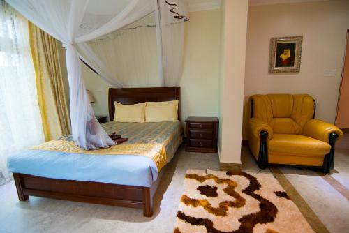 a bedroom with a canopy bed and a yellow chair at Naguru ViewPointe Apartments in Kampala