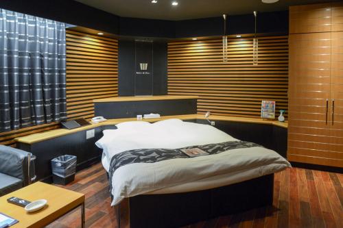 a bedroom with a large bed in a room withwindows at ホテル パレドフルー in Toyonaka