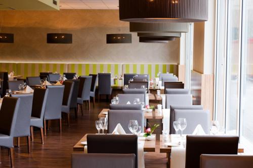 a dining room with tables and chairs with wine glasses at Mercure Hotel Hamburg am Volkspark in Hamburg