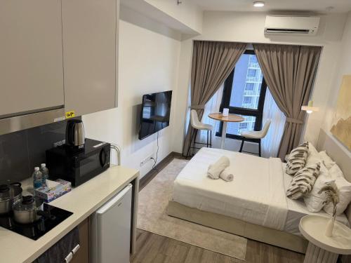 a small hotel room with a bed and a kitchen at Agile Residence Bukit Bintang by Luma in Kuala Lumpur