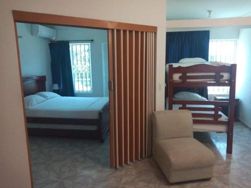 a bedroom with two bunk beds and a chair at Hotel Coosonav Cartagena in Cartagena de Indias