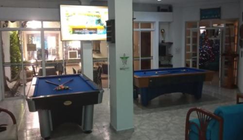 two pool tables in a room with a tv at Hotel Coosonav Cartagena in Cartagena de Indias