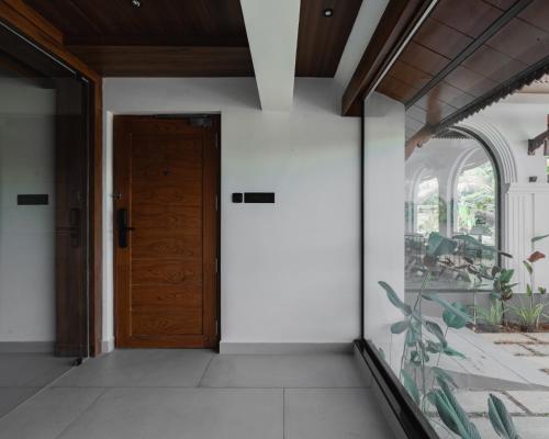 IrimbranallūrMayanadhi Resort的房屋内空空的走廊,有木门