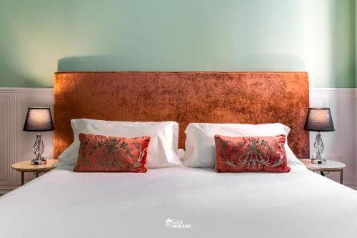 a white bed with two pillows and two lamps at MISTRO House & Courtyard - by Sleep in MURANO in Murano