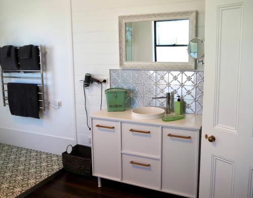 a bathroom with a sink and a mirror at Smithtown Champagne Bed and Bubbles in Smithtown
