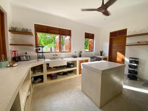 Una cocina con encimera y ventilador de techo en Tiwi Beachfront Family Villa, en Tiwi