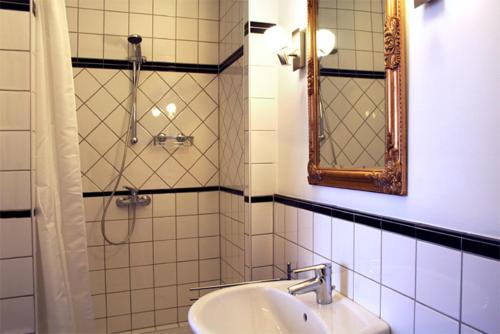 bagno con doccia, lavandino e specchio di Strumpfeck Suites a Traben-Trarbach