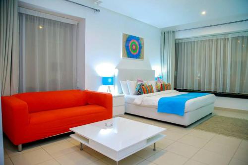 a living room with a bed and a red couch at Prime Hotel in Amman