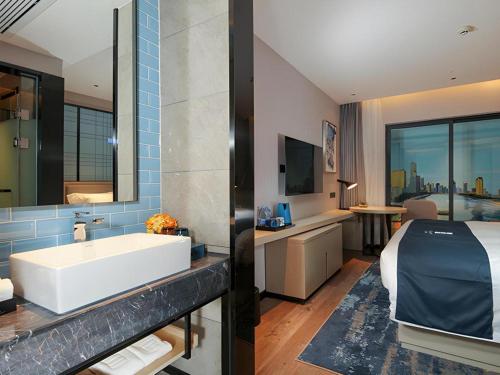 bagno con lavandino, letto e vasca di Echarm Hotel Chengdu Global Center Century City New Exhibition a Chengdu