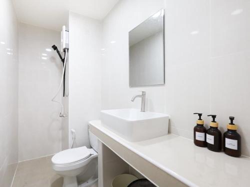 a white bathroom with a sink and a toilet at 3 Beds,WiFi,Washing Machine,IMPACT Arena at T9 in Ban Bang Phang