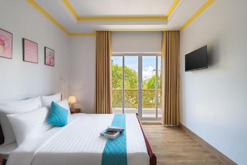 sypialnia z łóżkiem i dużym oknem w obiekcie Song Ngọc Hotel Phan Thiết w mieście Phan Thiet