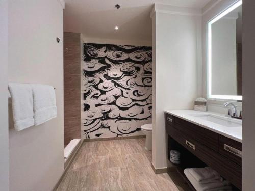 ein Badezimmer mit Toilette, Waschbecken und Spiegel in der Unterkunft Ahern Hotel and Event Center in Las Vegas