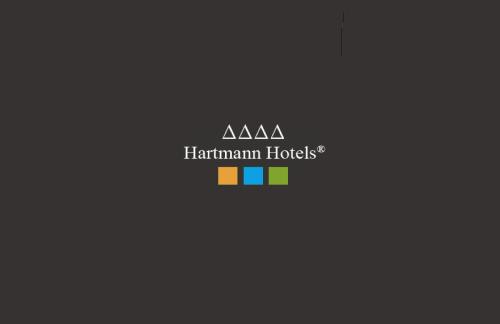 a logo for ahakman huts with a rainbow at Smart Hotel Saslong in Santa Cristina Gherdëina