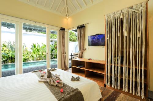 a bedroom with a bed with towels on it at Villas Edenia - Luxe Villas with Private Pools in Gili Trawangan