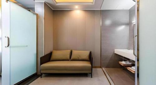 a chair sitting in a bathroom with a sink at GELI Kunming North Railway Station Zoo in Kunming