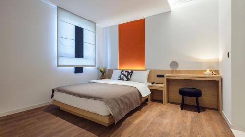 首尔Aank Hotel and Spa Seoul Seongsu Konkuk University的一间卧室,卧室旁边设有一张桌子和一扇窗户