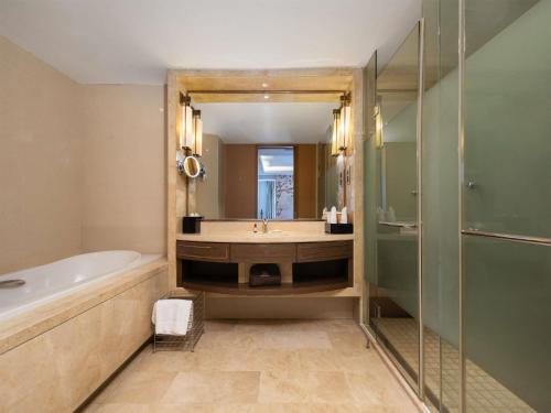 ein Badezimmer mit Badewanne, Waschbecken und Dusche in der Unterkunft Ramada Plaza By Wyndham Fuzhou South in Fuzhou