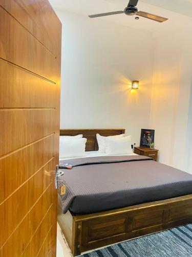 een slaapkamer met een bed en een houten deur bij Villa Mangrove Serenity in Galle